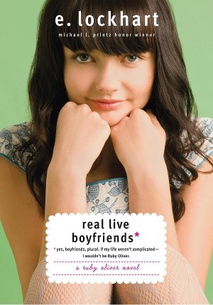 Cover of Real Live Boyfriends, with a cute white brunette girl with bangs, perching her chin on her hands and slightly smiling