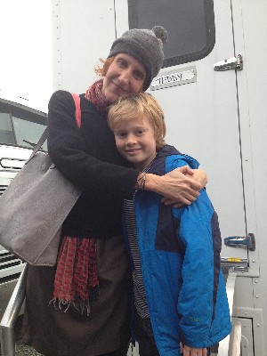 Gayle Forman with her arms side hugging a young, white, blonde boy who's smiling