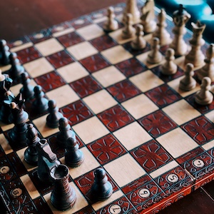 Wooden chess pieces on a ornate wooden board