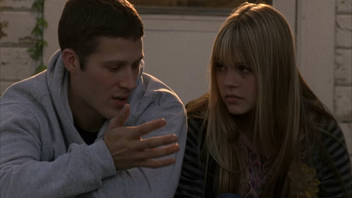 Matt, a blond white teenager, and Julie, a blonde white teenager, sit next to each other on porch steps.