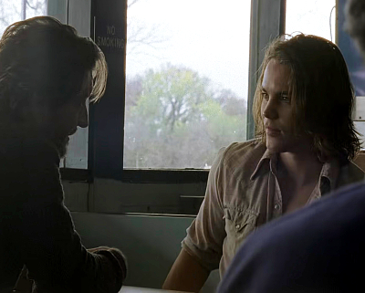 Tim Riggins, a young white man with shaggy brown hair, looks at his dad who sits across him from him at a diner table