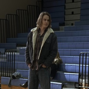 Tim Riggins, with shaggy brown hair, wearing a sherpa jean jacket with his hands in his jeans pockets