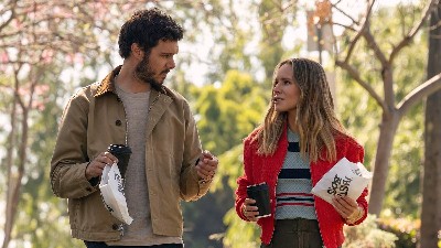 Adam Brody, a handsome white man with curly brown hair and a beard, walking and talking with Kristen Bell, a pretty white woman with long blonde hair