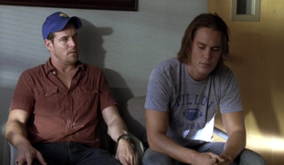 Billy and Tim sitting in an office, two white men cast as brothers, one in a polo shirt and the other in a Dillon Panthers t-shirt