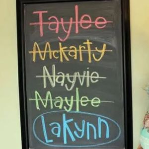 Photo of chalkboard with the following names in rainbow-coloured chalk, with all crossed out except the last is circled: Taylee, McKarty, Nayvie, Maylee, Lakynn