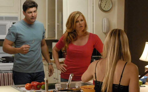 The Taylor family in their kitchen on Friday Night Lights, a brunette man and blonde woman facing a blonde teenage girl who has her back to us. The man and woman do NOT look happy.