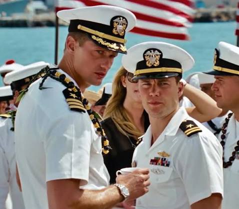 Alexander Skarsgard standing with Taylor Kitsch, both of them wearing white Naval uniforms and hats